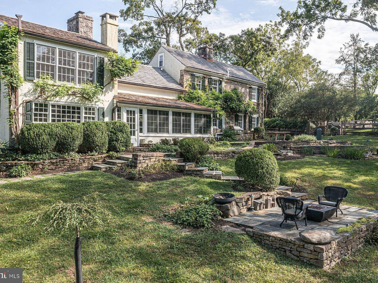 The house exterior with terraced gardens and fire pit